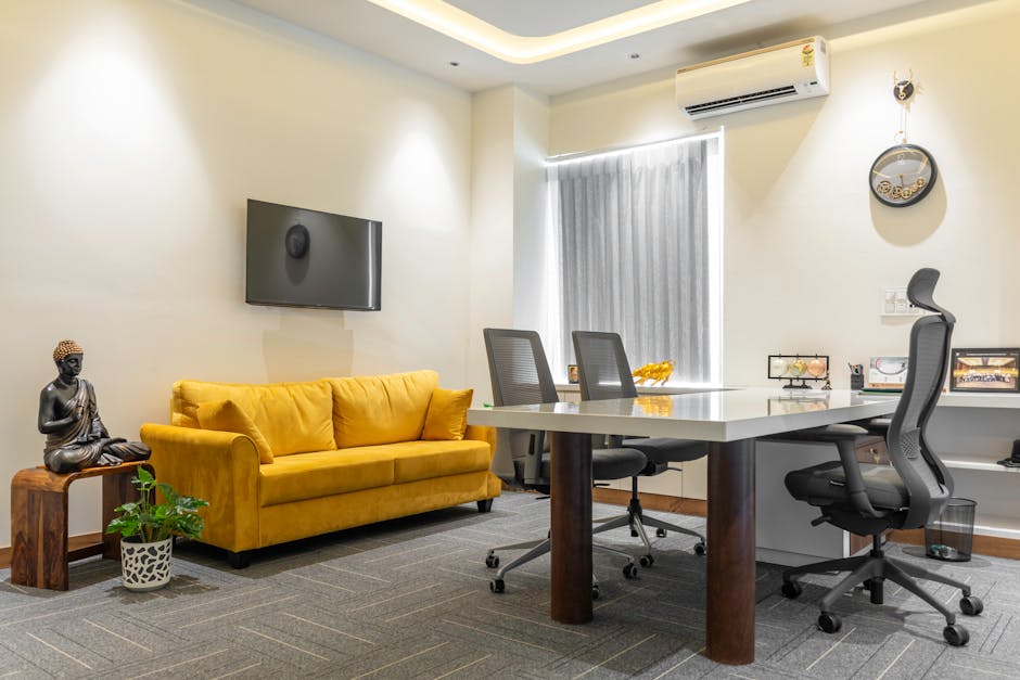 Stylish office space featuring a yellow sofa and Buddha decor.